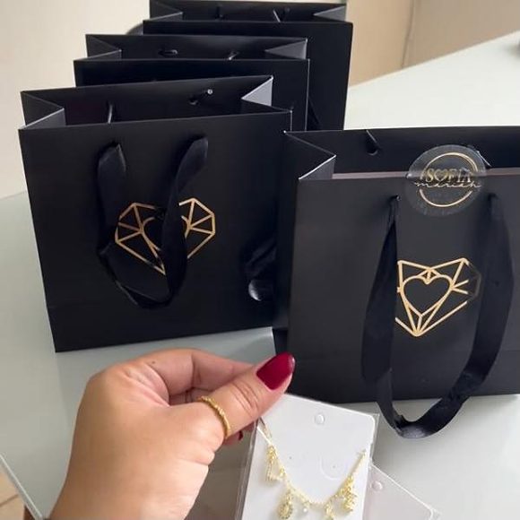 Sacolas pretas da Sofia Mariah Joias com o coração dourado da marca